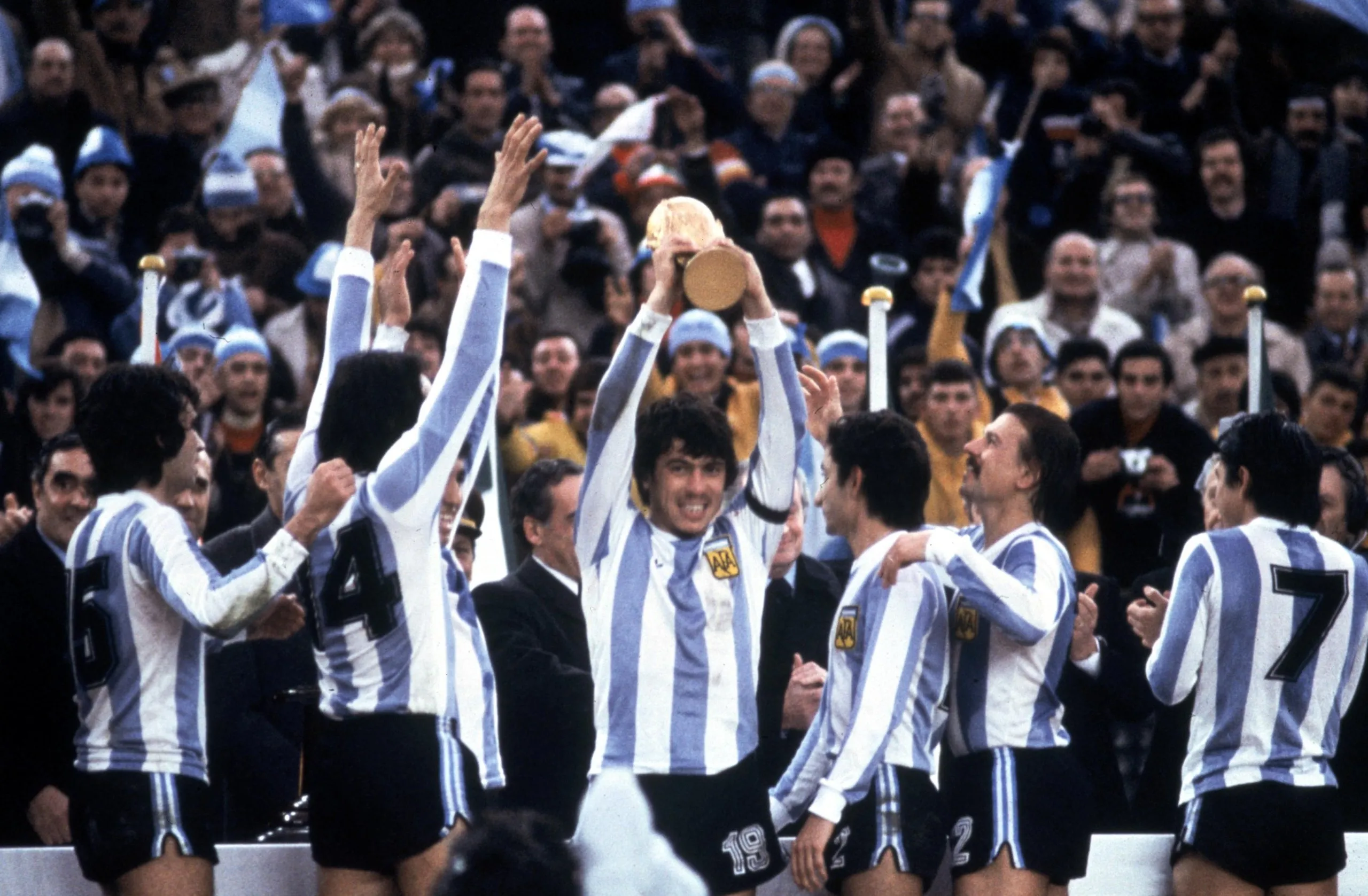 The Argentina captain, Daniel Passarella, lifts the World Cup trophy in 1978 as Ossie Ardiles (third right) looks on.