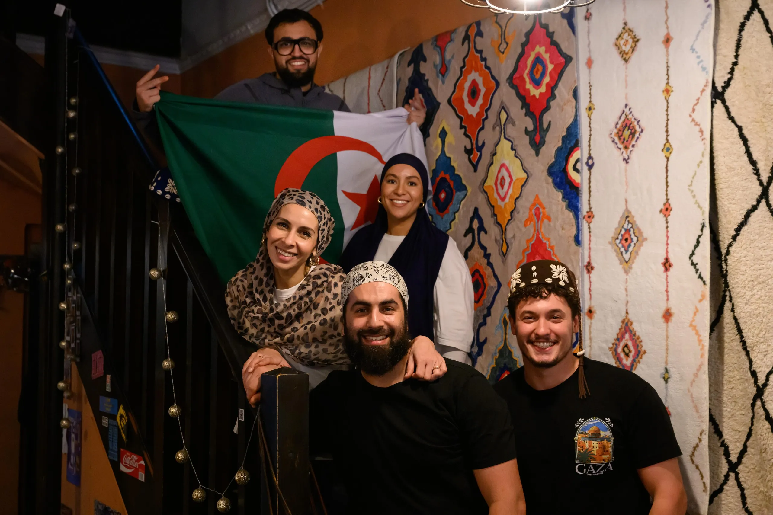 Cafe staff stand with an Algeria flag