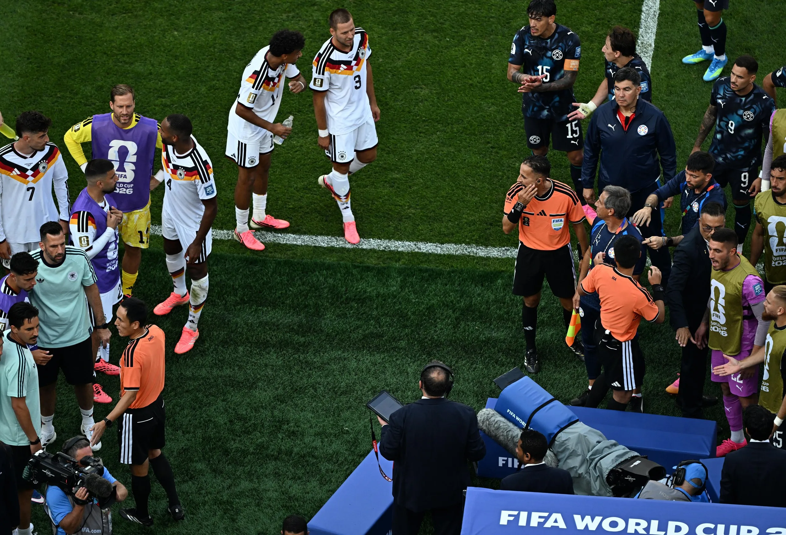 Moroccan referee Jalal Jayed is surrounded by players and staff as he checks the VAR before disallowing Jonathan Tah’s goal in extra time.