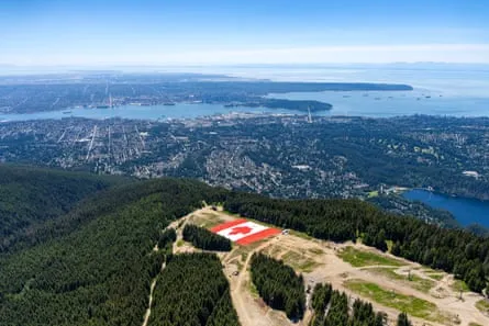 A giant Canadian flag on Grouse Mountain above the city of Vancouver, where the cost of the tournament has skyrockted