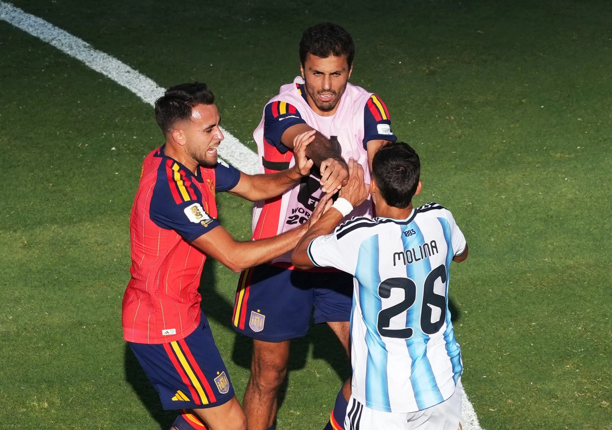 Spain’s Eric Garcia and Rodri argue with Argentina’s Nahuel Molina