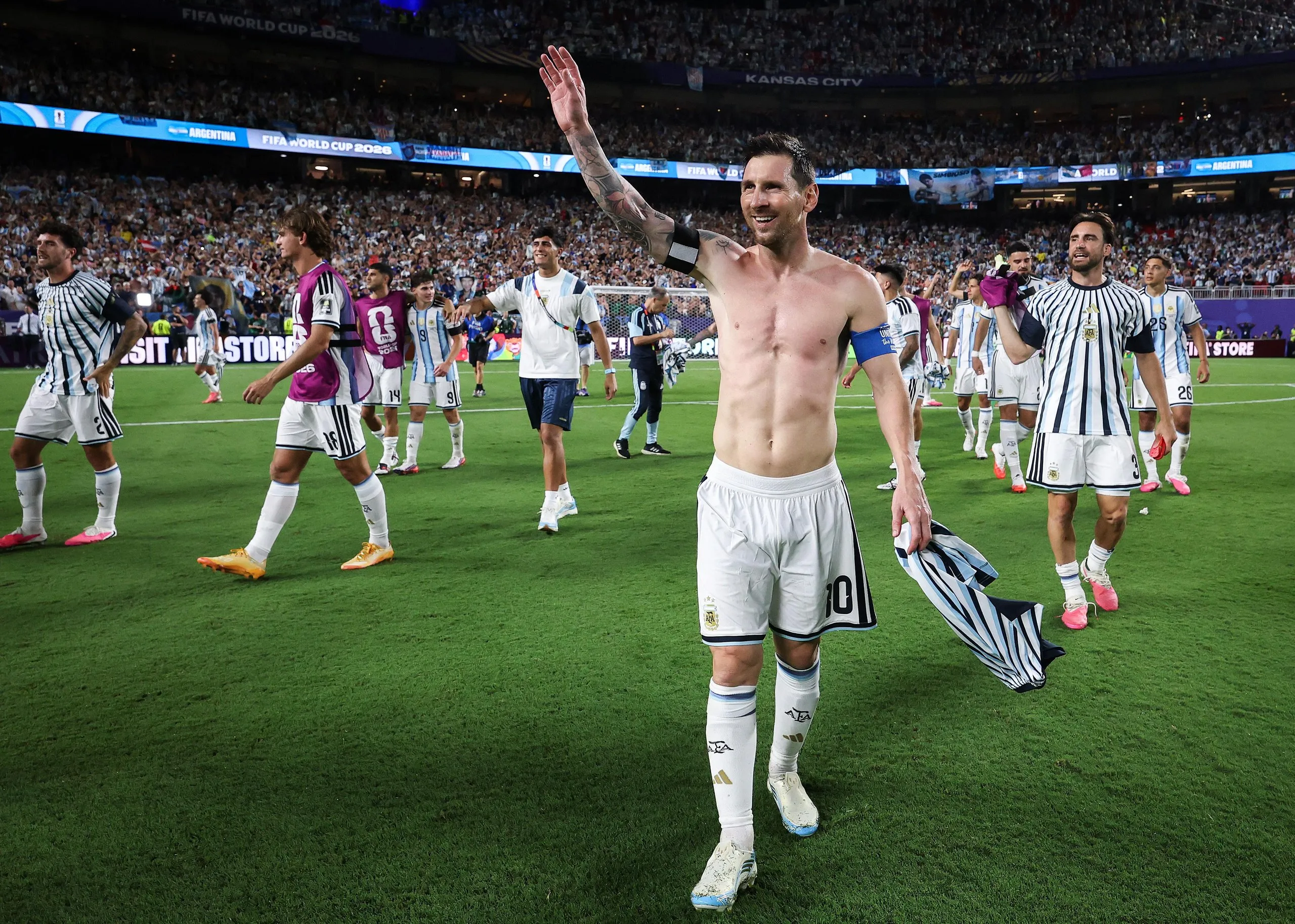 Lionel Messi celebrates with his top off